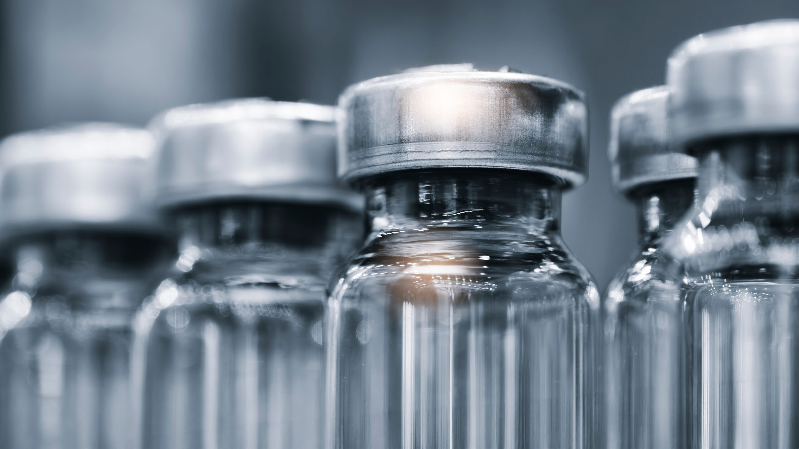 Professional medical glass vials for storing medicines and laboratory research of vaccines close-up at a pharmaceutical factory or hospital