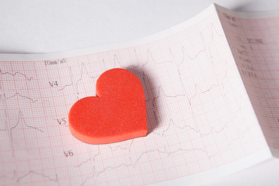 Red foam heart resting on an electrocardiogram tracing, suggesting heart health or Valentine's theme.
