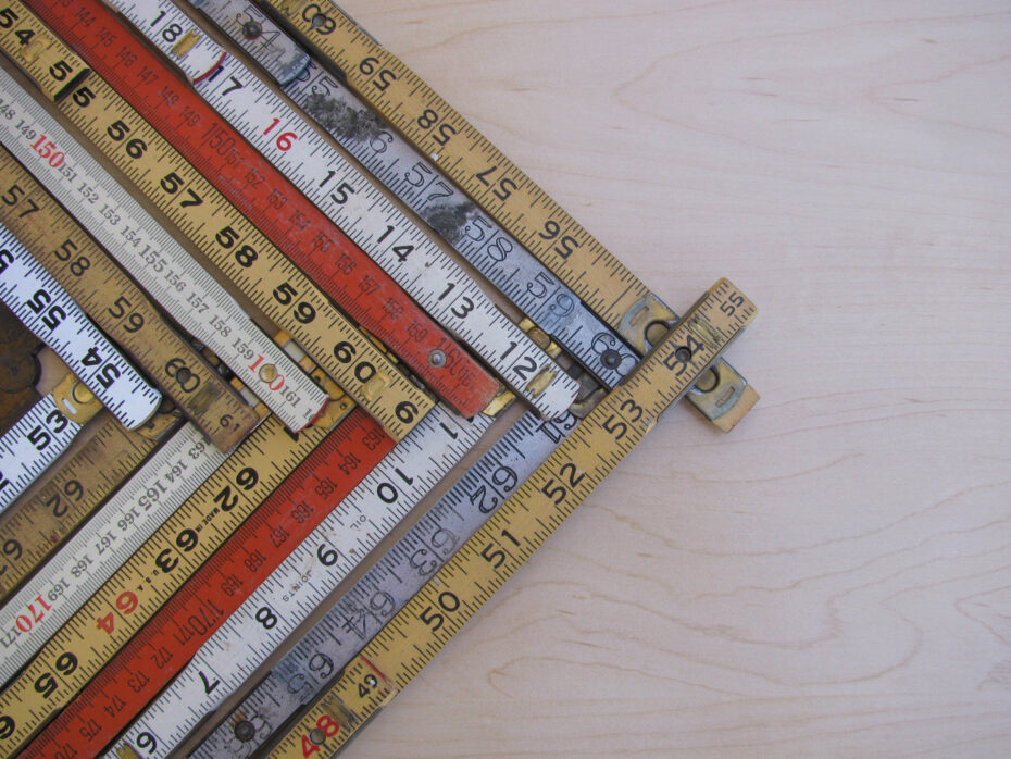 Rulers and scales in metric and inches form a chevron chart or graph representing accuracy measurement increase growth and results with copy space