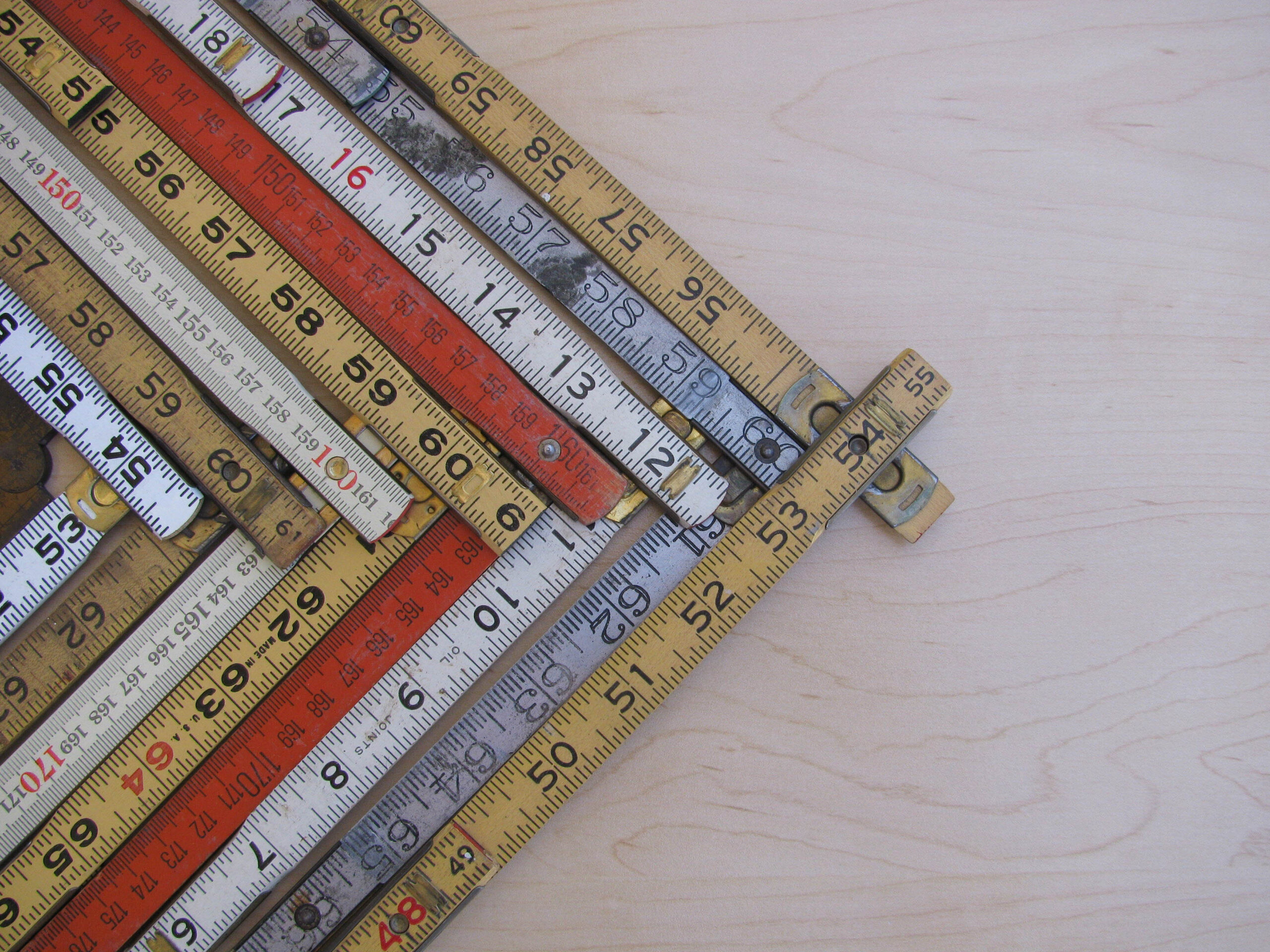 Rulers and scales in metric and inches form a chevron chart or graph representing accuracy measurement increase growth and results with copy space