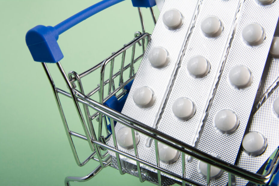 Pills on shopping cart Macro A variety of tablets and medicines in a mini shopping cart Medecine concept