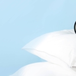 Alarm clock on the pillows. Advertising concept, copy space. Banner size