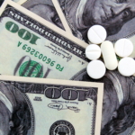 On the dollar money are white medicine pills.