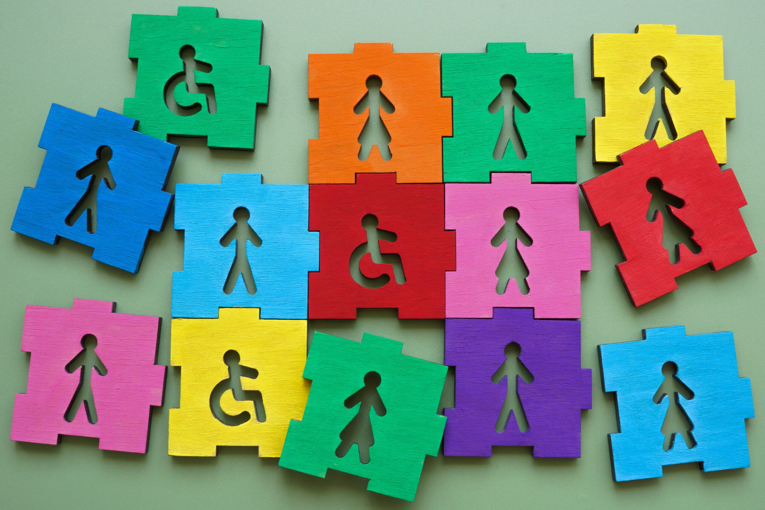 Colorful puzzle pieces with male female figures and disability sign representing inclusion and diversity