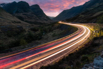 Car light trails on winding road through the highlands near Glen