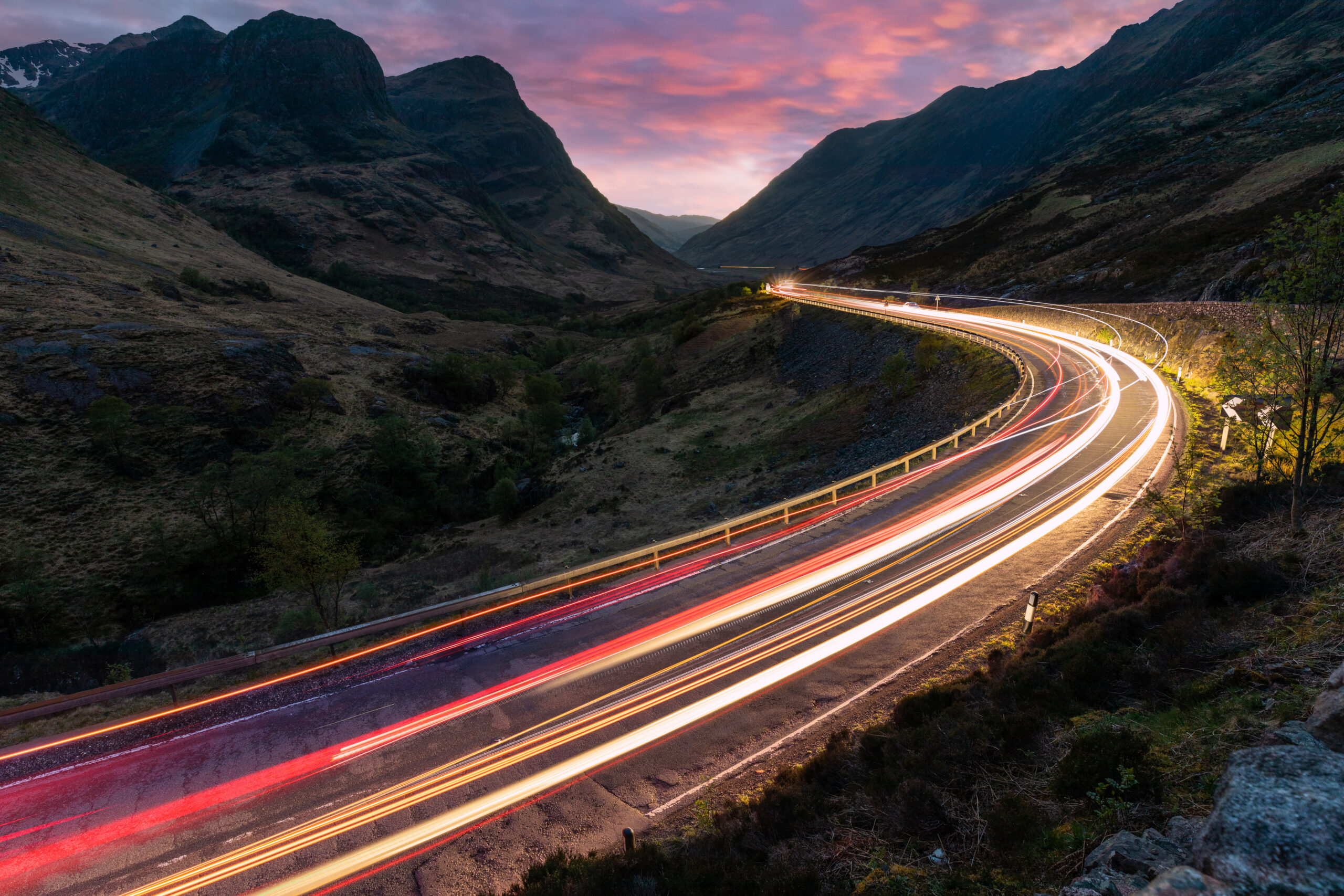 Car light trails on winding road through the highlands near Glen