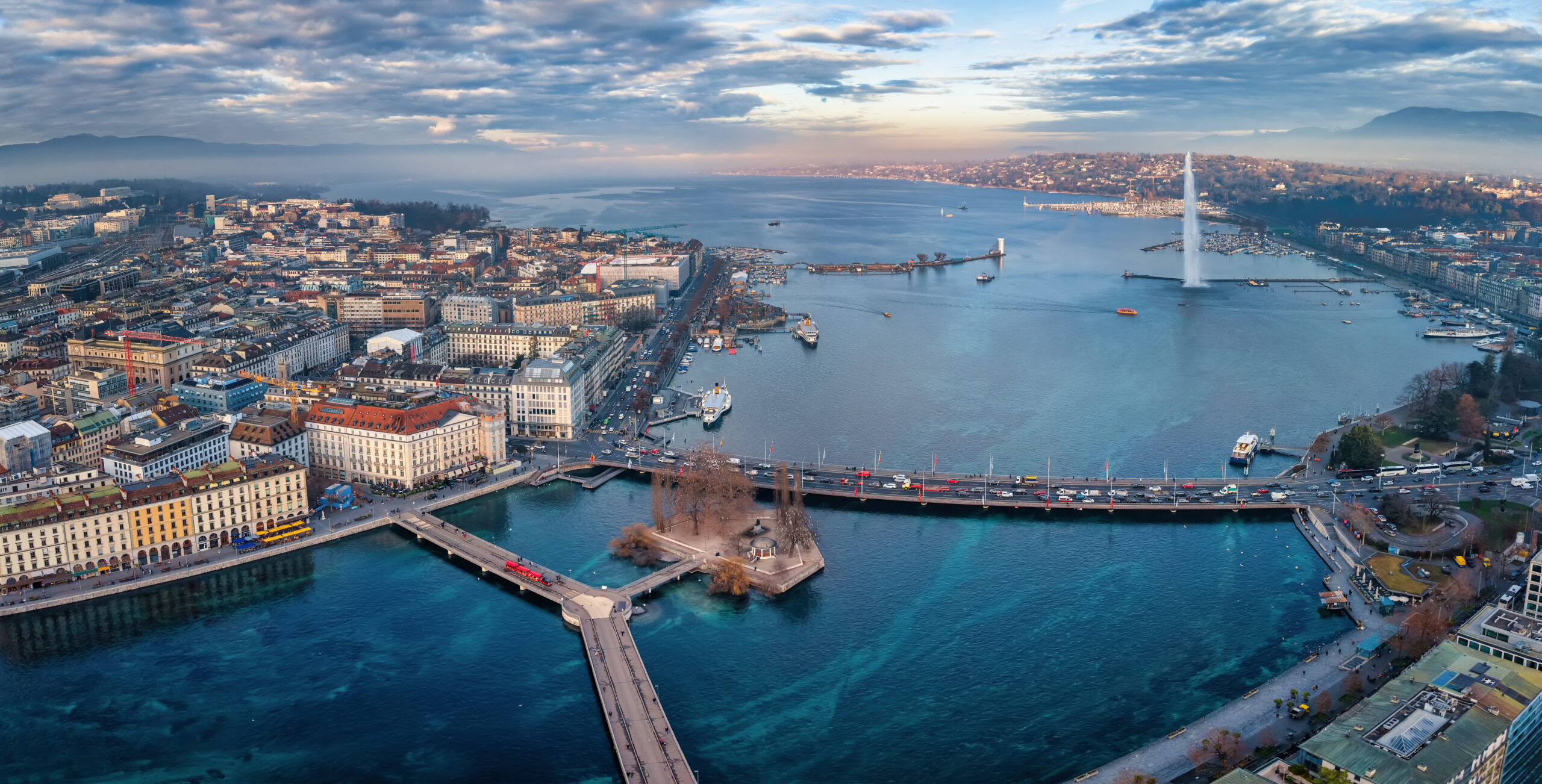 Aerial view of the cityscape and lake Geneva Switzerland during a winter sunset with fog clouds and sunshine