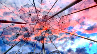 salonica umbrellas metallic street art sea fountain rain cloudy sky greece - OHE Abstract outdoor sculpture of overlapping transparent umbrella frames attached to metal poles against a pink and blue sunset sky.