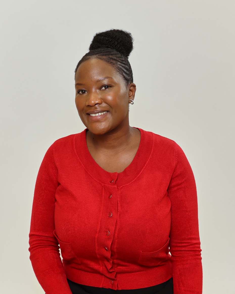 Smiling woman with a braided bun wearing a red cardigan against a light background.